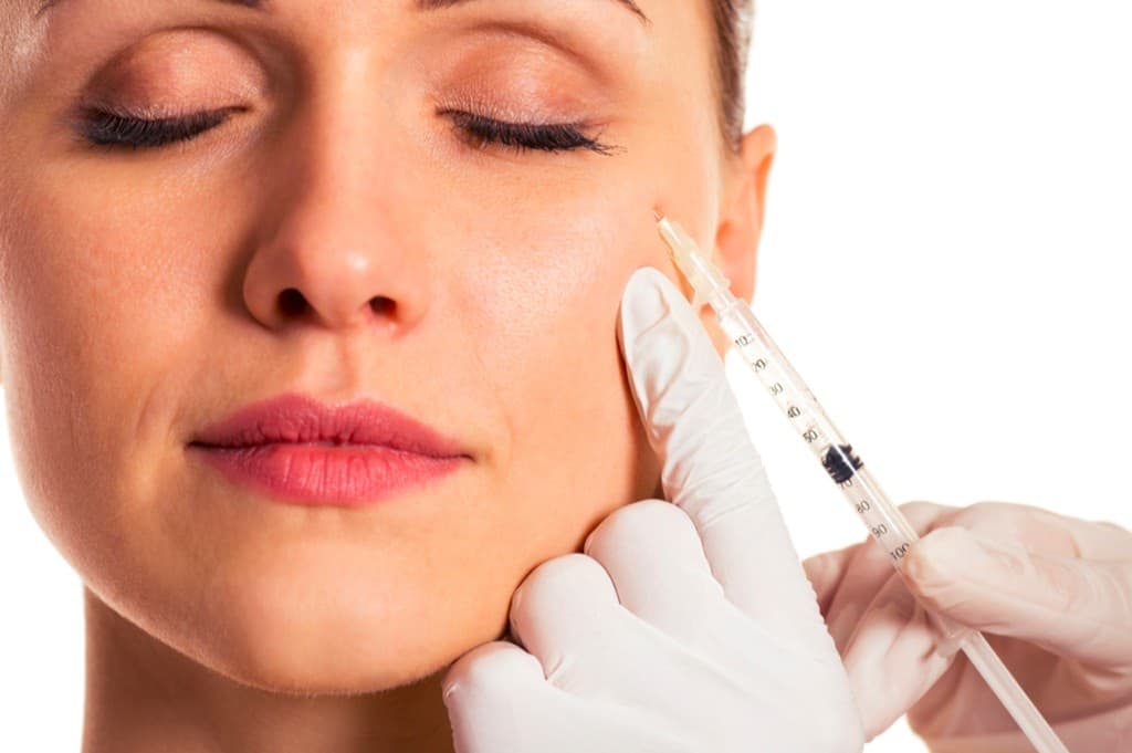 Anti-wrinkle injection treatment being administered to the cheek and eye area